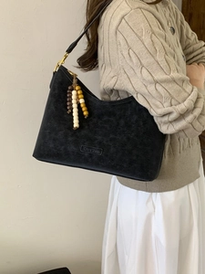 Retro black suede hobo shoulder bag with tassel detail and vintage half-moon design