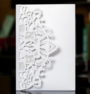 Détail de la carte en papier perlé blanc découpé au laser avec motifs de dentelle évidés