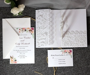 Lace laser cut wedding invitation set with floral card and envelope on elegant fabric