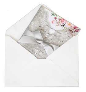 Silver glitter laser cut wedding invitation with grey satin bow and floral insert