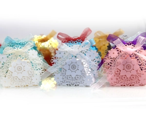Detailed laser-cut floral candy boxes in various colors with elegant organza ribbons