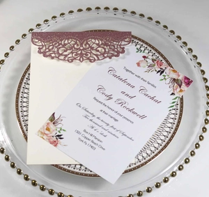 Detail of rose gold laser-cut glitter wedding invitation on elegant dinner plate
