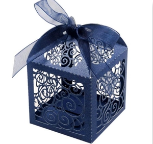 Close-up of laser-cut heart patterns and organza ribbon on navy blue favor box
