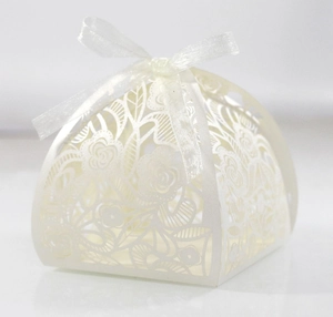Detail van witte lasergesneden geschenkdoos met bloemmotieven en een zijden strik