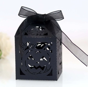 Detailed laser-cut Jack-o'-lantern pattern on black paper candy box with ribbon