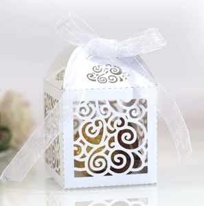 Detail of white laser-cut gift box with floral patterns and a white organza ribbon bow