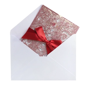 Elegant rose gold glitter laser-cut lace wedding invitation with red satin ribbon bow