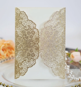 Detail of laser-cut wedding invitation with champagne gold glitter lace floral patterns