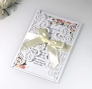 Détail du faire-part de mariage découpé au laser avec étui blanc et ruban beige