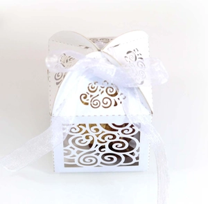 Detailed laser-cut heart pattern on white paper candy box with organza ribbon