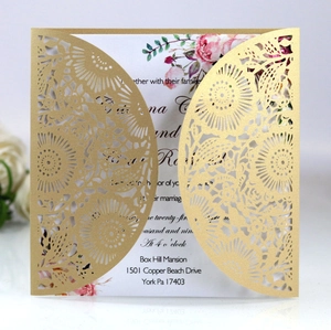 Detail view of laser-cut golden hollow wedding invitation with floral insert card