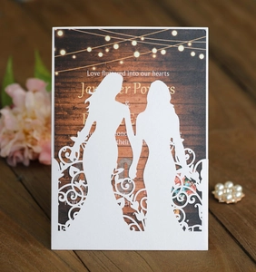 Detail of laser-cut wedding invitation featuring two girls silhouette and wood grain card