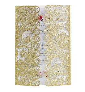 Close-up of golden glitter laser cut wedding invitation with floral printed inner card
