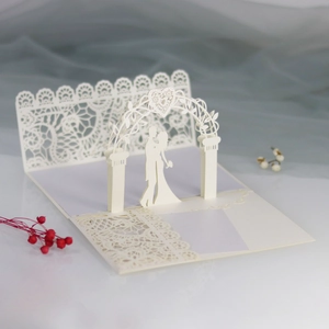 Detail of white 3D laser-cut wedding card featuring a lace arch and couple silhouette