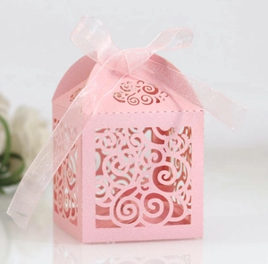 Pink laser-cut gift box with intricate vine patterns and matching ribbon bow detail