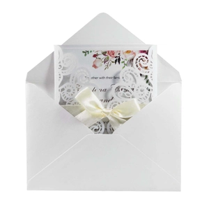 Détail d'invitation de mariage découpée au laser avec ruban blanc et carte intérieure