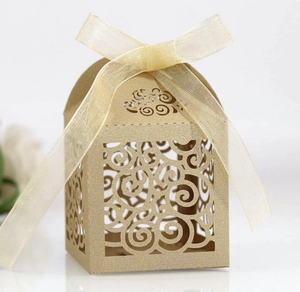 Detail of laser-cut heart pattern gift box in champagne gold with chiffon ribbon bow