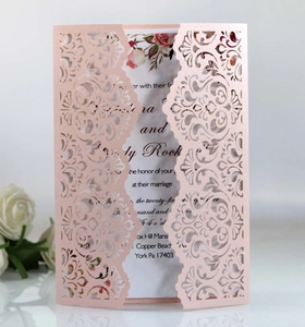 Macro detail of laser-cut floral wedding invitation card with rose gold hollow pattern