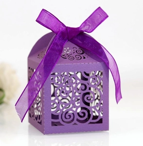 Detail of purple laser-cut candy box with scroll patterns and satin ribbon bow