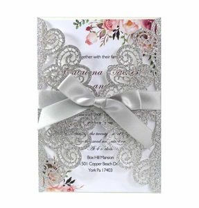 Détail d'invitation de mariage argentée découpée au laser avec paillettes et ruban