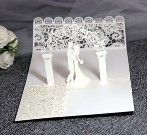 Detail of 3D laser-cut wedding invitation featuring a romantic couple under heart arch