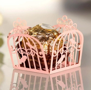 Close-up of pink laser-cut birdcage candy box with pearl paper floral patterns