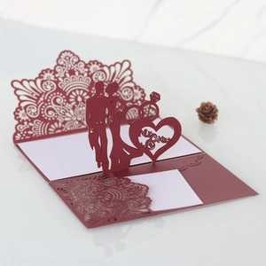 Detail of laser-cut 3D wedding card in wine red featuring Mr & Mrs silhouettes