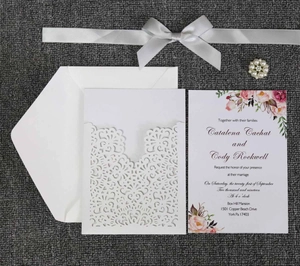 Detailed laser-cut wedding invitation set with floral inner card and pearl ribbon