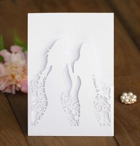 Detailed laser-cut white wedding card featuring two female silhouettes on wood background