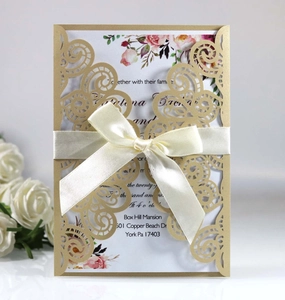 Détail de l'invitation de mariage découpée au laser avec coque dorée et nœud satin