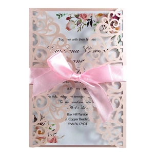 Laser cut wedding invitation in rose gold with a pink silk bow and floral insert card