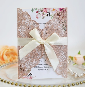 Laser cut rose gold glitter wedding invitation with elegant cream ribbon and floral card