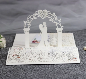 Detail of 3D laser-cut wedding invitation featuring a romantic couple silhouette and lace