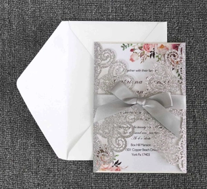 Détail d'invitation de mariage découpée au laser pailleté argent avec ruban de satin gris