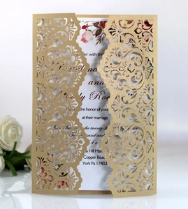 Intricate laser-cut floral pattern on golden wedding invitation with rose detail
