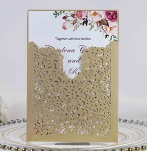 Close-up of laser-cut gold wedding invitation card with elegant floral inner sheet