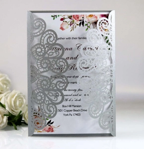 Détail d'invitation de mariage découpée au laser argenté avec dentelle et paillettes