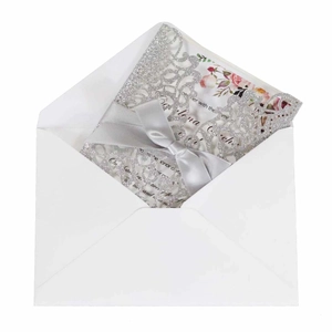Silver laser cut wedding invitation with white envelope and gray satin bow decoration