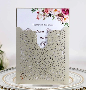 Detail of laser-cut floral champagne wedding invitation with elegant peony insert card