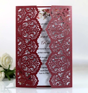 Intricate laser-cut floral details on a burgundy glitter wedding invitation card set