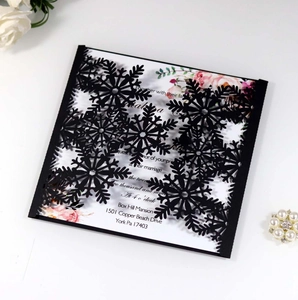 Macro view of laser-cut black snowflake invitation card with elegant floral details