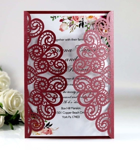 Détail d'invitation de mariage bordeaux découpée au laser avec motif floral élégant