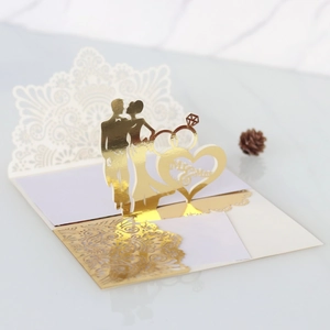 Detail of 3D laser-cut wedding card featuring golden Mr & Mrs silhouettes and lace patterns