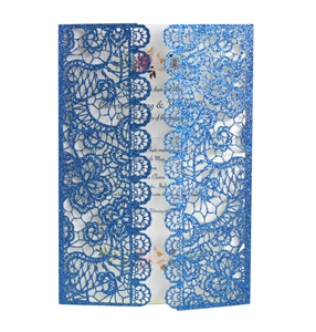 Close-up of blue glitter laser-cut wedding invitation with elegant lace hollow pattern