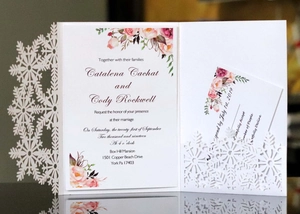 Macro view of laser-cut snowflake hollow lace wedding invitations on high-grade white paper