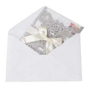 Glittery silver laser-cut snowflake invitation with white envelope and cream satin ribbon