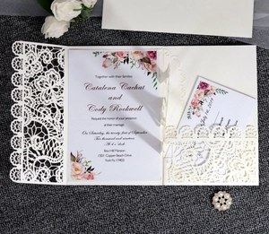 Close-up of laser-cut lace wedding invitation with floral insert and RSVP card set