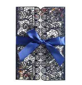 Detailed laser-cut wedding invitation with blue glitter lace and satin ribbon bow