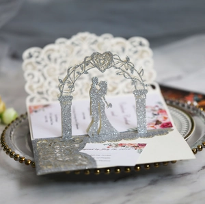 Detail of 3D laser-cut wedding invitation featuring silver glitter arch and romantic couple