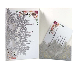 Detail of silver glitter snowflake laser-cut pocket with floral wedding invitation cards